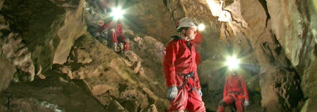 Cavers exploring the caverns and cave features in the Rat's Nest Cave at Grotto Mountain in Canmore, Alberta
