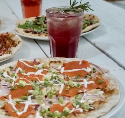 Pizza paired with a delicious cocktail at Rocky Mountain Flatbread Co. in Canmore, Alberta