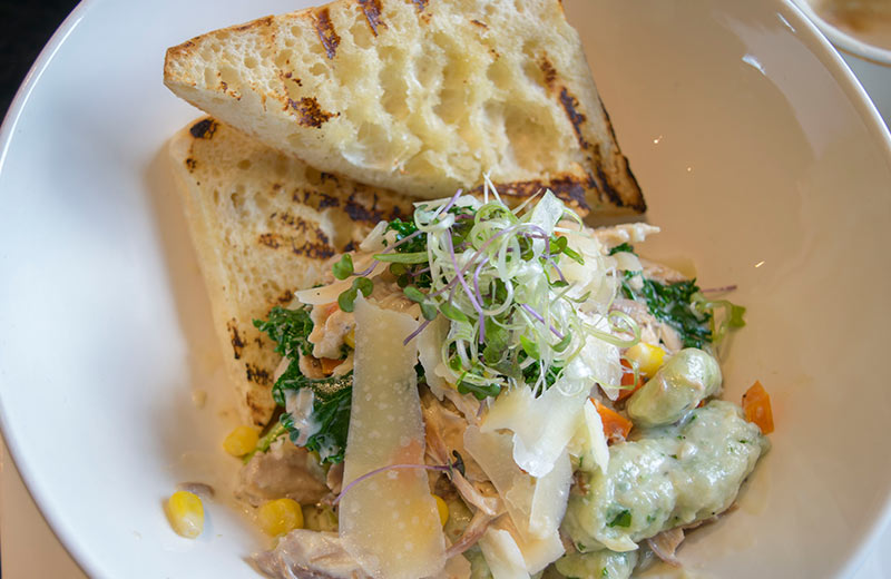 A bowl of pasta with a side of garlic bread.  The Thursday dining special at The Grande Kitchen + Bar