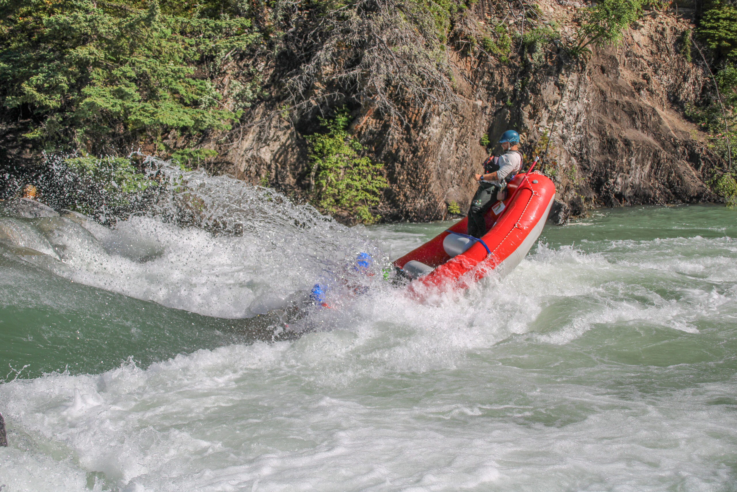 Rafters on the Kananaskis Surf Trip in a red raft on the Kananaskis River with Canadian Rockies Rafting