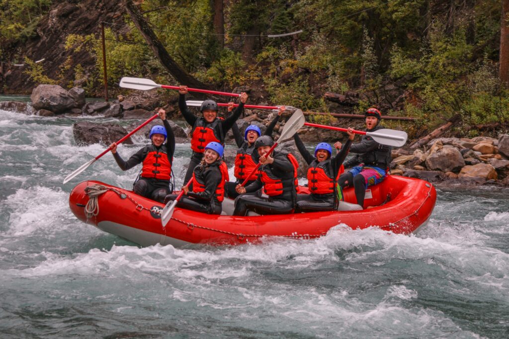 Fully geared up in wetsuits and wetsuit jackets, rafting the Kananaskis River with Canadian Rockies Rafting.